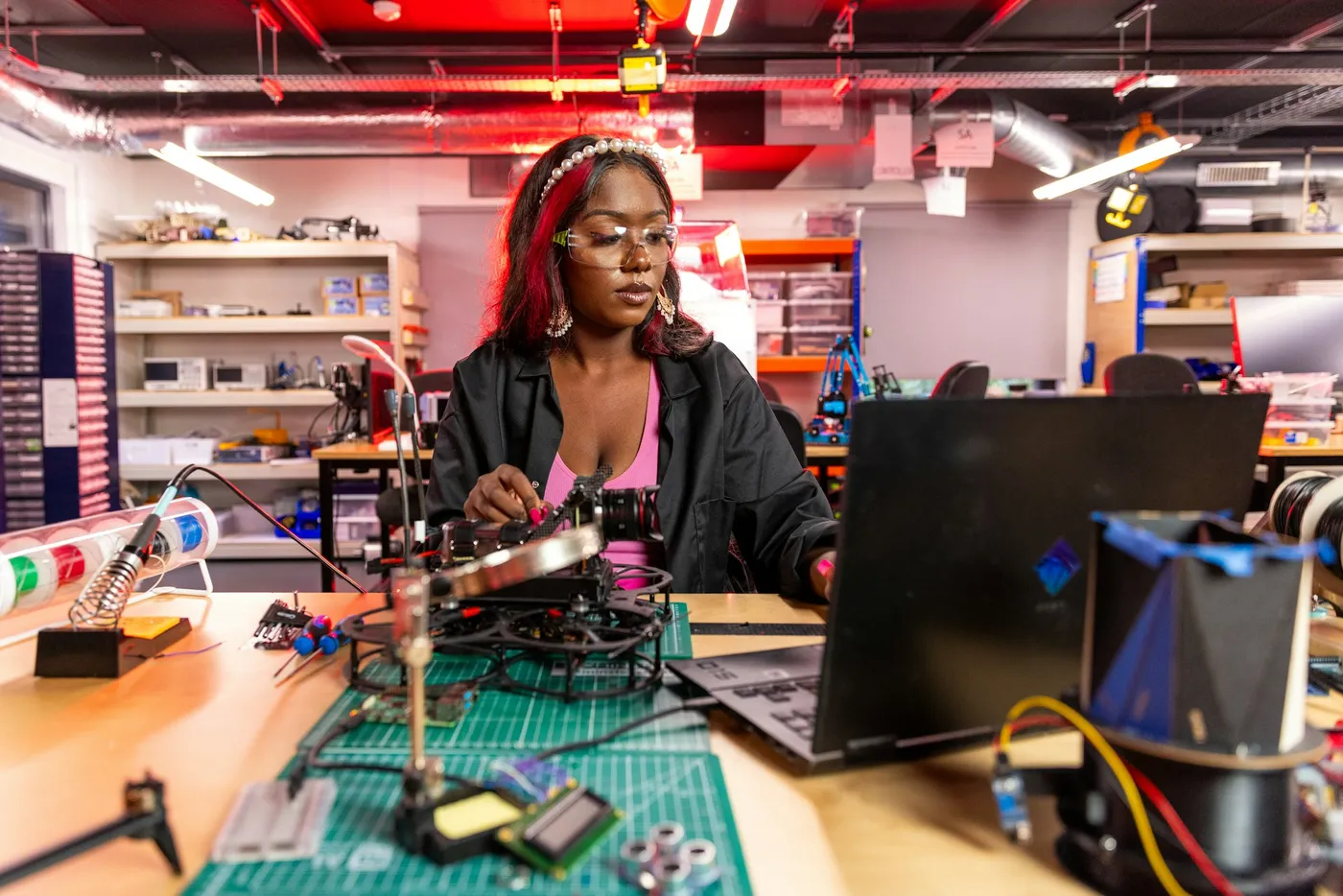 An engineer working at a laptop in an electronics lab