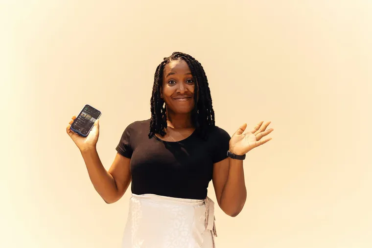 A smiling woman holding her phone