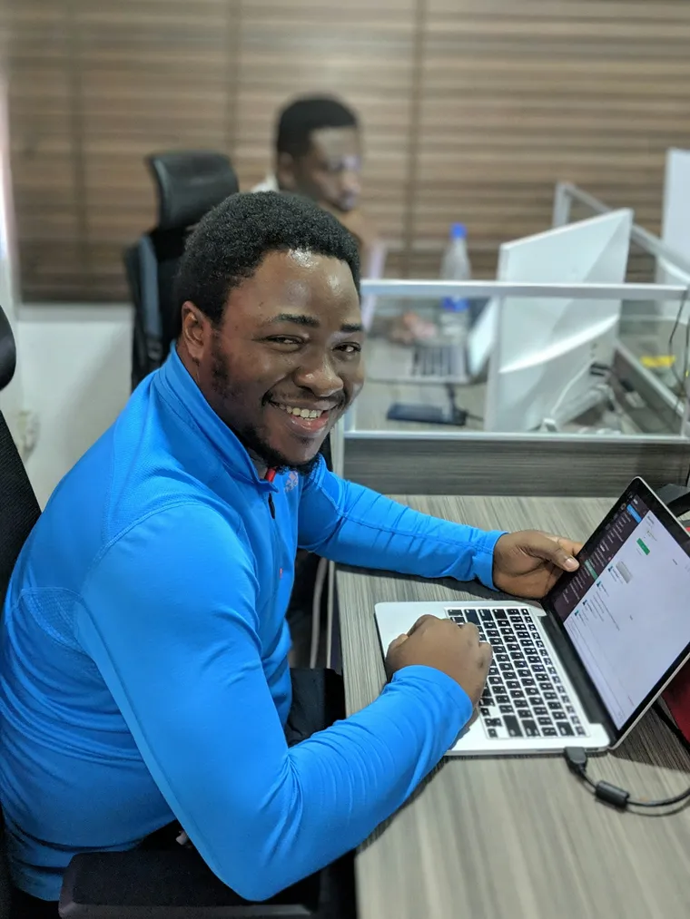 A man in a blue shirt working on a laptop