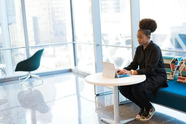 A woman working on a laptop in a bright office
